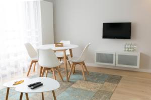 sala de estar con mesa, sillas y TV en Chopin Apartments, en Cracovia