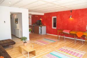 a living room with a table and a red wall at Ecrin de verdure avec accès piscine en plein Aix in Aix-en-Provence