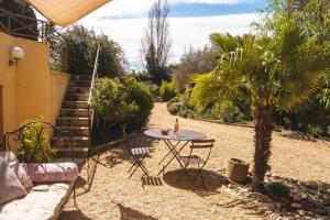 a patio with a table and a palm tree at Ecrin de verdure avec accès piscine en plein Aix in Aix-en-Provence