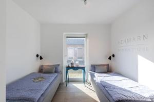 two beds in a room with a table at lovely&cool STIL-HAUS in Fehmarn