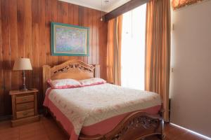 a bedroom with a bed with pink pillows and a window at Casa Hotel Sura in San José