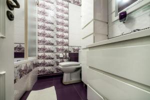 une salle de bain avec toilettes et un mur carrelé dans l'établissement Apartamenty on Kryvonosa, à Lviv 7 autres photos