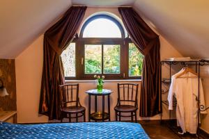 a bedroom with a bed and chairs in front of a window at Daiconi Boutique House in Miniş +71 photos