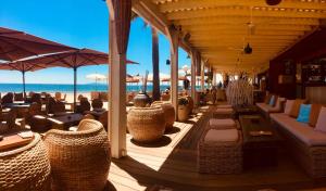 ラ・ロンド・レ・モールにあるLes Romarinsのビーチのレストラン(椅子、パラソル付)