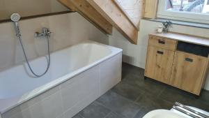 a bathroom with a bath tub and a sink at Ferienapartment bavarian living in Moosinning