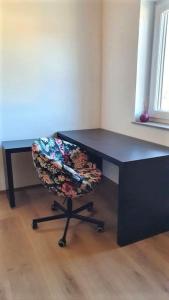 uma secretária preta com uma cadeira num quarto em Ferienapartment bavarian living em Moosinning