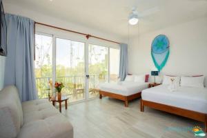 um quarto com 2 camas, um sofá e uma janela em Ocean Zen Suites on 5th Avenue - Adults Only em Playa del Carmen