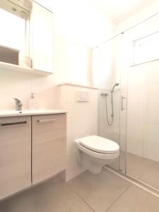 a white bathroom with a toilet and a shower at Superior apt, 4 rooms, 4 bathrooms in Promajna +27 photos