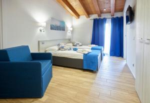 a bedroom with a bed and two blue chairs at Il Beccaria Relais B&B in Fondi