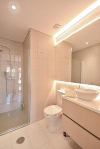 a bathroom with a toilet and a sink and a shower at Peixinho Avenue Apartment in Aveiro