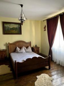 a bedroom with a bed and a large window at The Hunter House in Ciudanoviţa