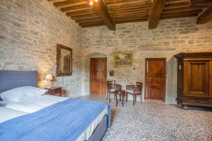 a bedroom with a bed and a table and chairs at Country House Villa La Farfalla in Pietralunga