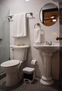 a bathroom with a toilet and a sink and a mirror at Hotel Santa Ana in Mérida +69 photos