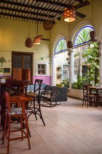 restauracja z drewnianymi stołami, krzesłami i oknami w obiekcie Hotel Santa Ana w mieście Mérida