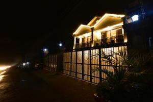 une maison avec des lumières sur son côté la nuit dans l'établissement ENTEBBE STAY Apart-Hotel, à Entebbe