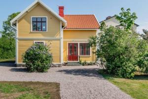 a yellow house with a red door at Casa Fontenay charmig lägenhet nära stadsparken och Vättern in Hjo