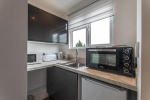 a kitchen with a microwave oven and a sink at Super cosy self-catering studio flat in Gillingham
