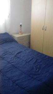 een slaapkamer met een blauw bed en een kast bij Family villa fantastic location in Lliria