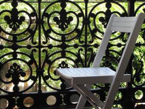 una silla blanca sentada frente a una valla de hierro en 06 Soho Suites en Buenos Aires