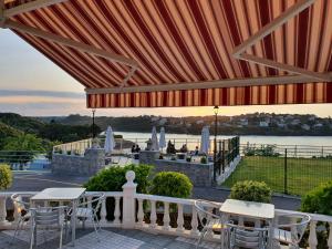 a patio with tables and chairs and a view of the water at Camping Playa la Arena in Isla