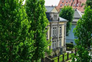 ein altes Gebäude mit Bäumen davor in der Unterkunft Villa Schmidt in Pirna