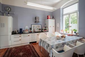 cocina con mesa, armarios blancos y ventana en Villa Schmidt, en Pirna