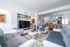 Una sala de estar con un sofá y un televisor. en Villa Pizzelli, en Dubrovnik