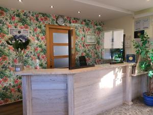 - un bar dans une pièce ornée d'un papier peint à fleurs dans l'établissement Camping Playa la Arena, à Isla