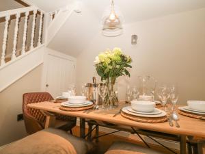 a dining room table with a vase of flowers on it at Brookhouse in Castleton