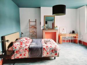 a bedroom with a bed with a table and a desk at La Villa 30 in Lille