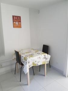 a table with two chairs and a tablecloth on it at Studio neuf meublé Rosny-sous-Bois in Rosny-sous-Bois