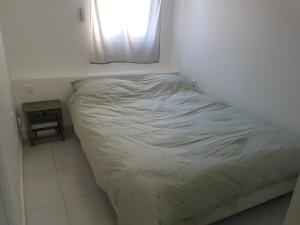 a small bed in a room with a window at Studio neuf meublé Rosny-sous-Bois in Rosny-sous-Bois