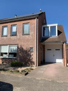 una casa de ladrillo con puertas blancas y entrada en Lise's Place, en Vrouwenpolder