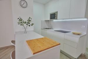 a kitchen with white counters and a clock on the wall at ABLANCAS - La Restinga in La Restinga
