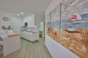 a kitchen with a painting of boats on the wall at ABLANCAS - La Restinga in La Restinga