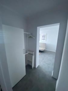 un corridoio con una camera con un letto e una porta di APARTAMENT OŚ. JASNE 19B a Dzierżoniów