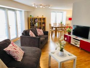 - un salon avec deux canapés et une télévision dans l'établissement Remarkable 2 Bed Apartment in Edinburgh, à Édimbourg