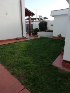 a yard with green grass next to a house at Sole e mare in San Felice Circeo