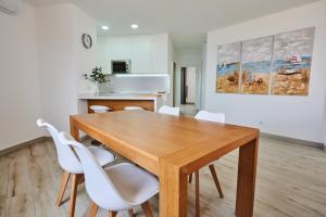 a dining room with a wooden table and white chairs at ABLANCAS - La Restinga in La Restinga