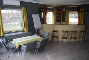 a room with a table and chairs and a counter at Casa Napsugár Panzió in Apostag