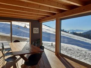 une salle à manger avec une table et une grande fenêtre dans l'établissement Alpine Dream Chalet with Spa close to Lake Geneva, à Les Mosses