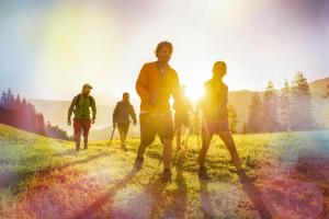 a group of people walking on a hill at sunset at Hotel Vierjahreszeiten in Flachau +283 photos