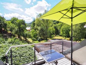 a yellow umbrella and a chair on a deck at Scherfsmühle am Mühlbach in Waldrach