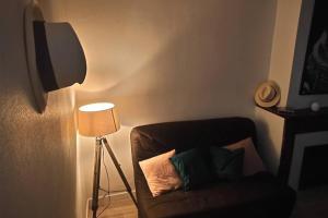 Gîte Le Lau-Kal في Septfonds: غرفة معيشة مع أريكة ومصباح