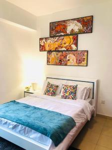 a bedroom with a bed with two paintings on the wall at Luxury Casa - Royal Sea View Apartment JBR Beach 2BR in Dubai
