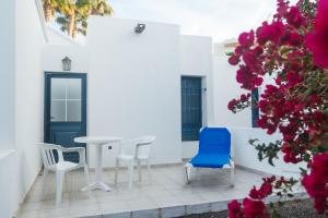 un patio con mesa, sillas y flores en Mar Azul Playa, en Puerto del Carmen