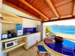 a kitchen with a table and a view of the ocean at la vista the view in Zihuatanejo