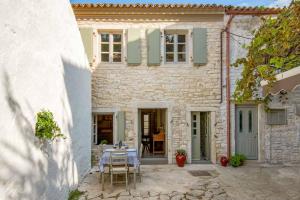 a stone house with a table in front of it at Lakka Stone House 0 in Gaios