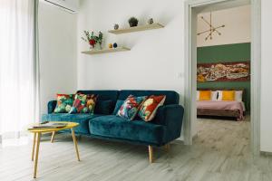 uma sala de estar com um sofá azul e uma mesa em La Sciara Etna Home em Linguaglossa