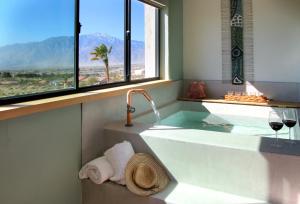 a bathroom with a tub with a view of the mountains at Azure Palm Hot Springs in Desert Hot Springs